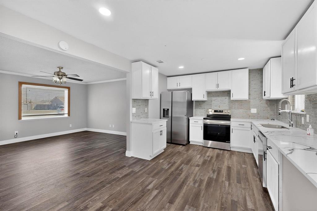 104 Maxwell Road Hackberry, TX 75036 - Photo 7 of 32 a kitchen with stainless steel appliances a refrigerator sink and cabinets