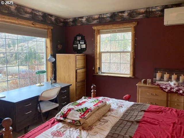 a bedroom with a bed and large windows