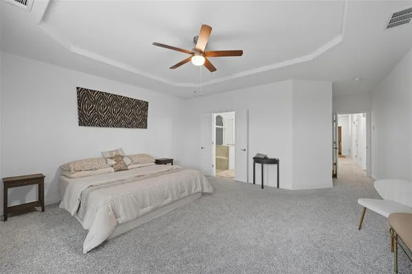 a spacious bedroom with a bed and a chandelier