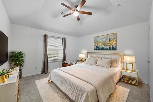 a bedroom with a large bed and a chandelier