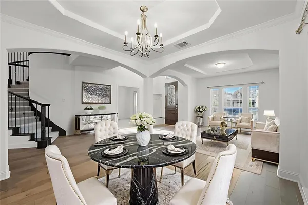 a view of a dining room with furniture wooden floor and chandelier