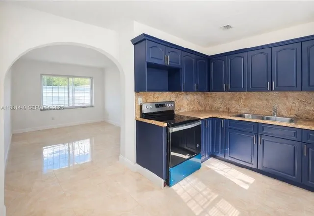 a kitchen with granite countertop wooden cabinets and stainless steel appliances