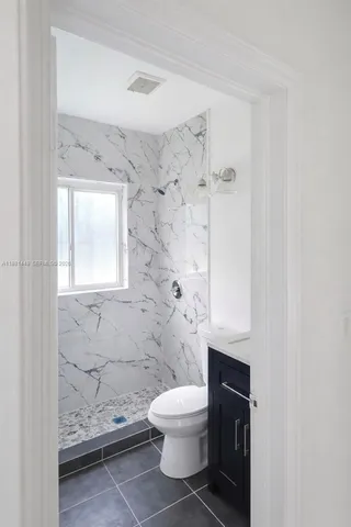 a bathroom with a toilet and a shower