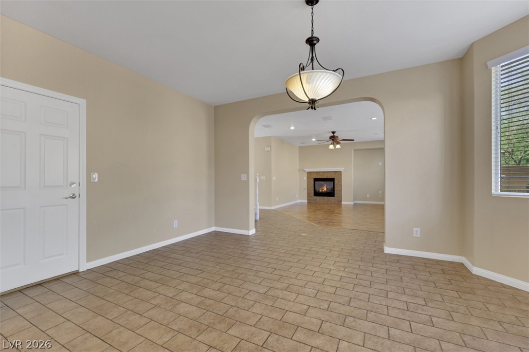 10328 Hawk Ravine Street Las Vegas, NV 89178 - Photo 11 of 55 An inviting interior offers distinct flooring and a cozy fireplace in the adjacent living space.
