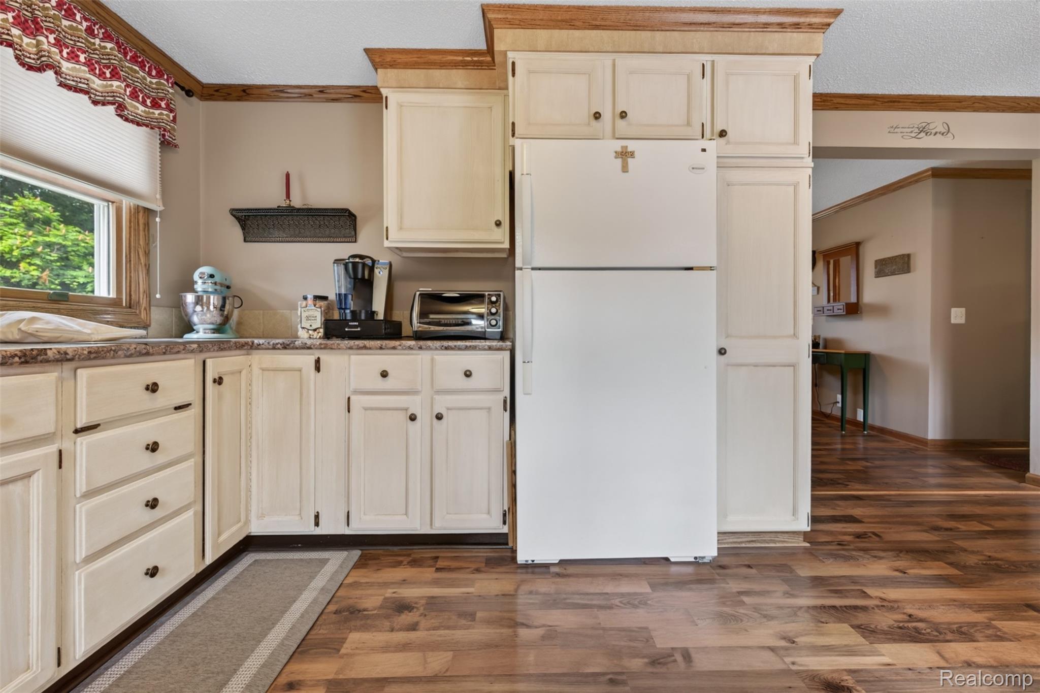 5977 Anglers Road Ortonville, MI 48462 - Photo 12 of 63 Kitchen featuring cream cabinetry with dark hardware, a white refrigerator, and wood-finish flooring