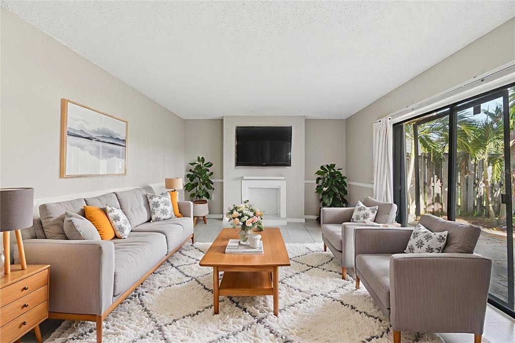238 Woodland Road Palm Springs, FL 33461 - Photo 2 of 33 a living room with furniture a flat screen tv and a large window