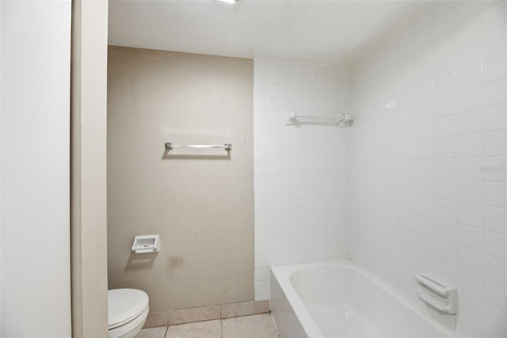 238 Woodland Road Palm Springs, FL 33461 - Photo 24 of 33 a bathroom with a granite countertop toilet and a bathtub