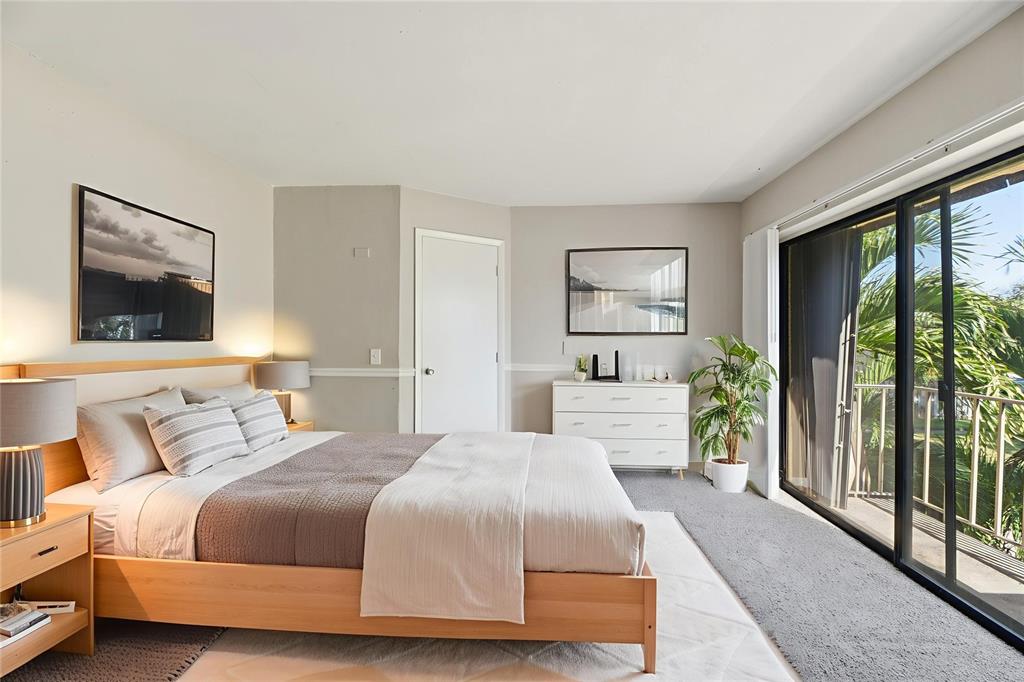 238 Woodland Road Palm Springs, FL 33461 - Photo 5 of 33 a bedroom with a large bed and a flat tv screen