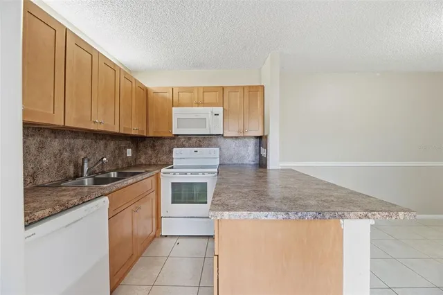 a kitchen with stainless steel appliances granite countertop white cabinets sink and a granite counter top