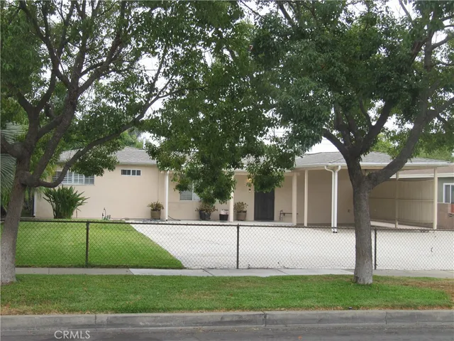 a view of a white house in a big yard with large tree