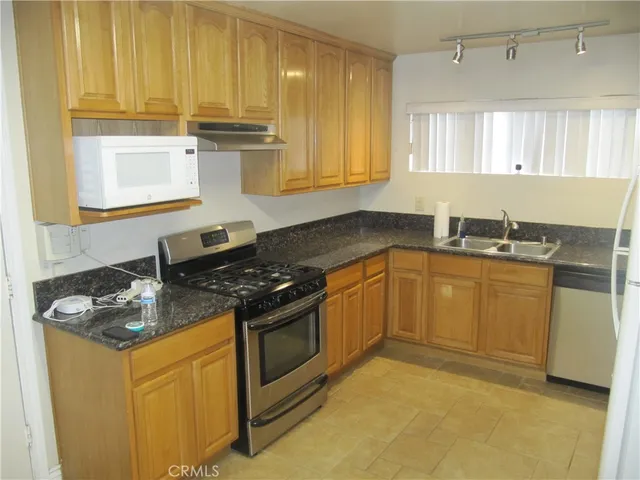 a kitchen with stainless steel appliances granite countertop a sink stove and cabinets