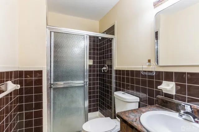 a bathroom with a toilet a sink and mirror