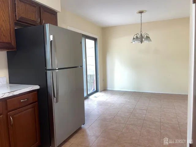 a view of a kitchen with a refrigerator and cabinets