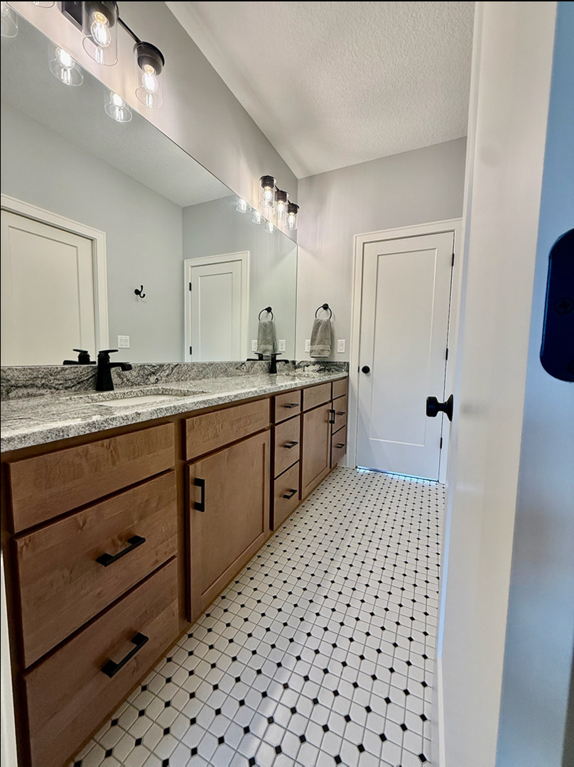 5077 Oak Rdg Court Bettendorf, IA 52722 - Photo 21 of 35 a bathroom with a sink a toilet a mirror and shower