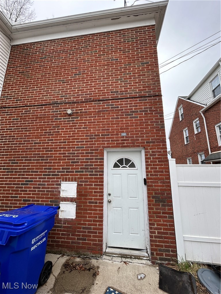 13678 Cedar Road Cleveland, OH 44118 - Photo 12 of 24 Back entrance to upper unit with fence and brick siding