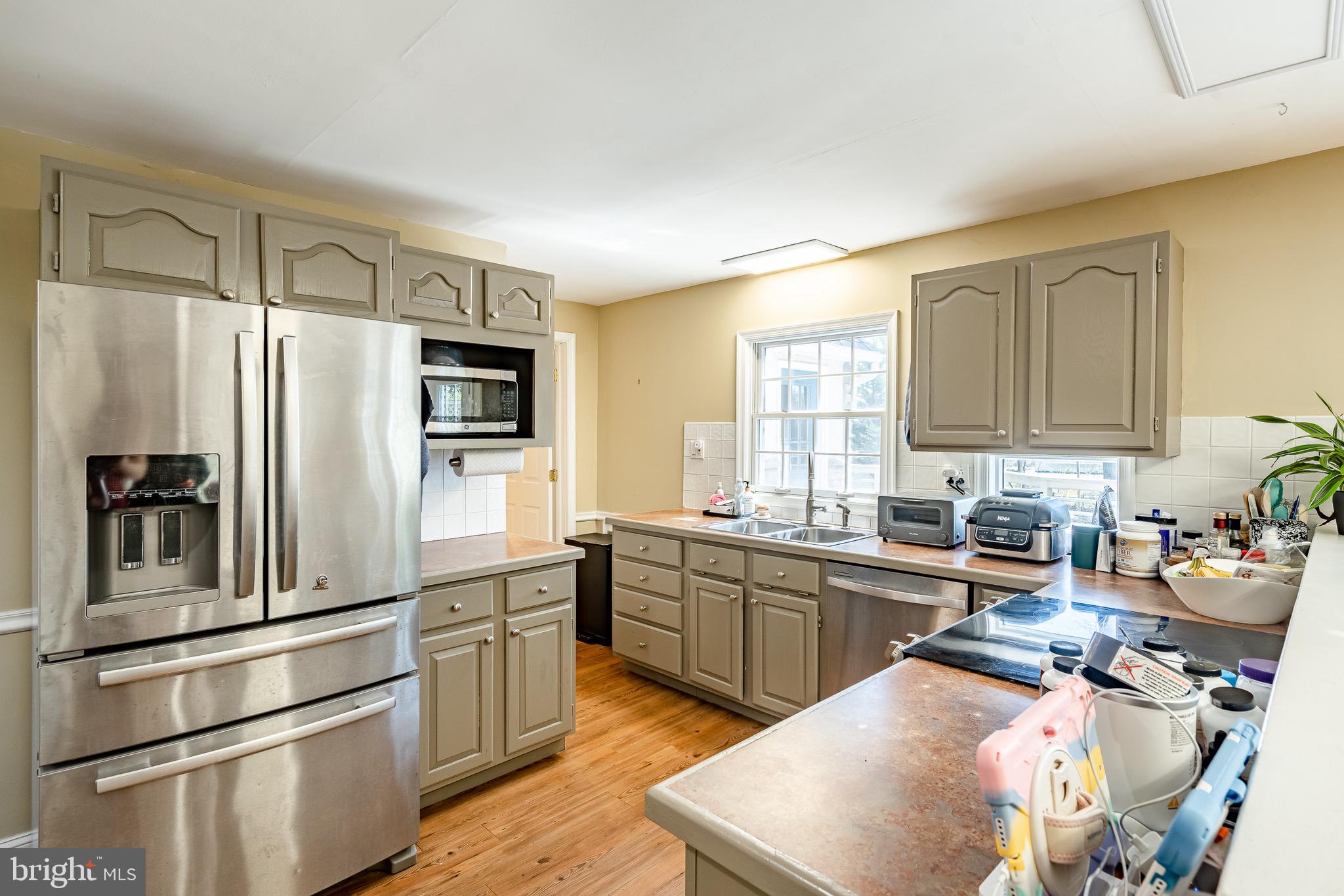 108 Devonwood Lane Devon, PA 19333 - Photo 11 of 55 a kitchen with stainless steel appliances granite countertop a refrigerator a sink dishwasher a stove with wooden cabinets and floor