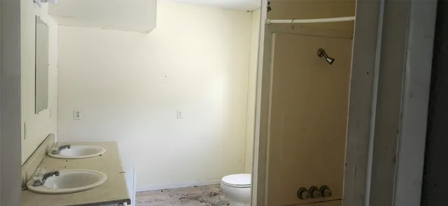 a bathroom with a granite countertop toilet and sink