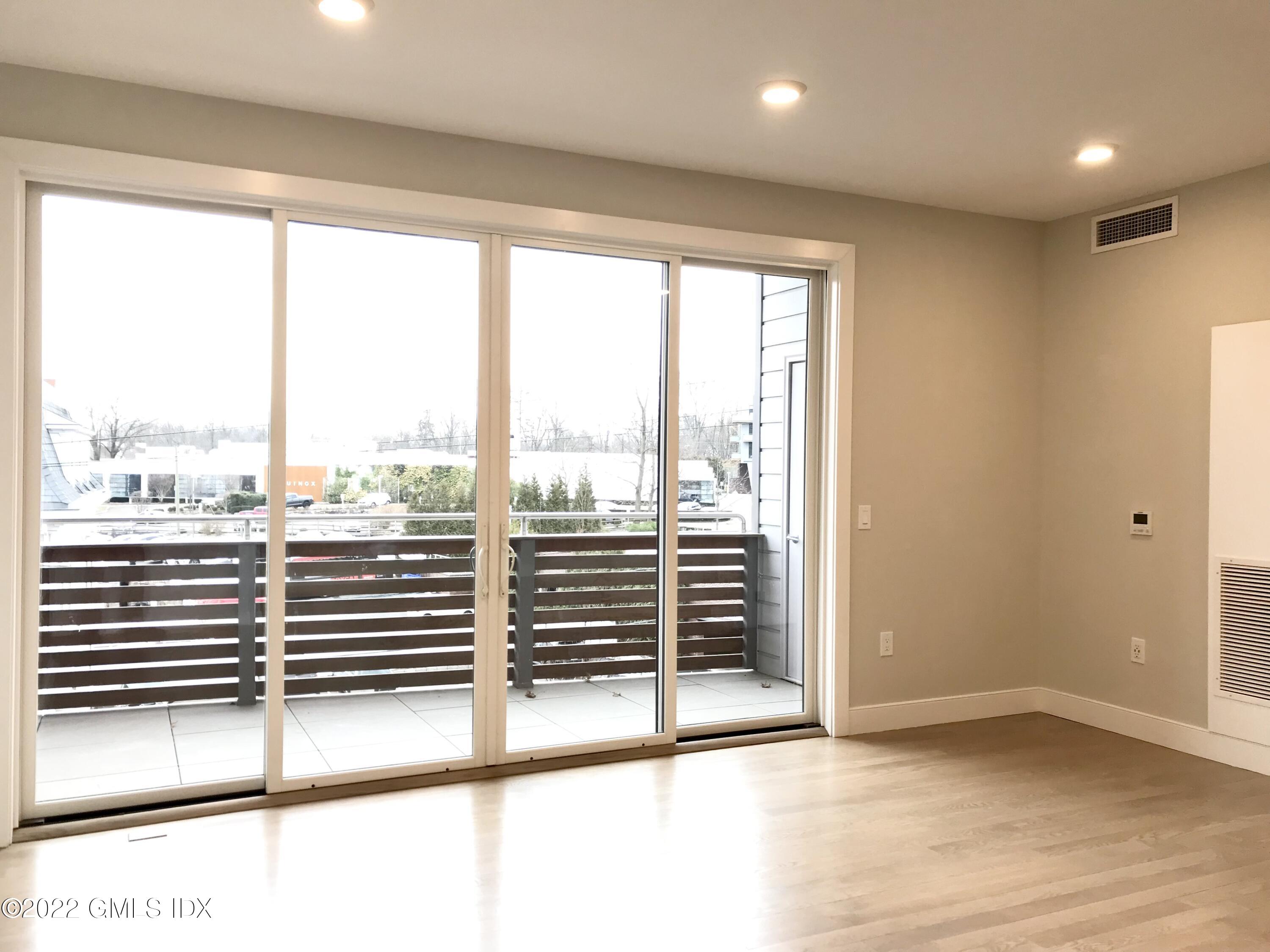 56 Old Field Point Road, Unit 6 Greenwich, CT 06830 - Photo 16 of 28 an empty room with wooden floor and windows