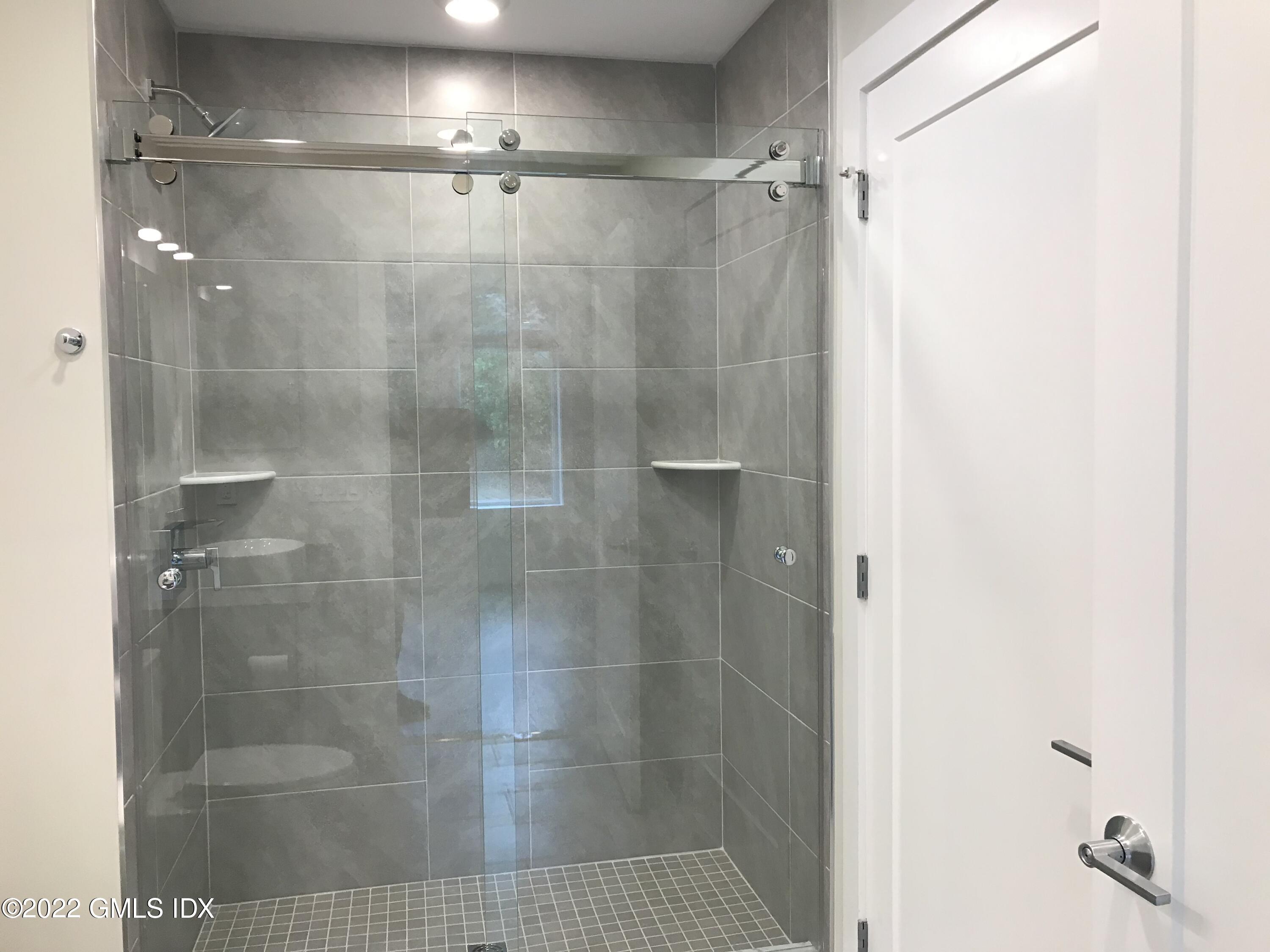 56 Old Field Point Road, Unit 6 Greenwich, CT 06830 - Photo 22 of 28 a bathroom with a glass shower door