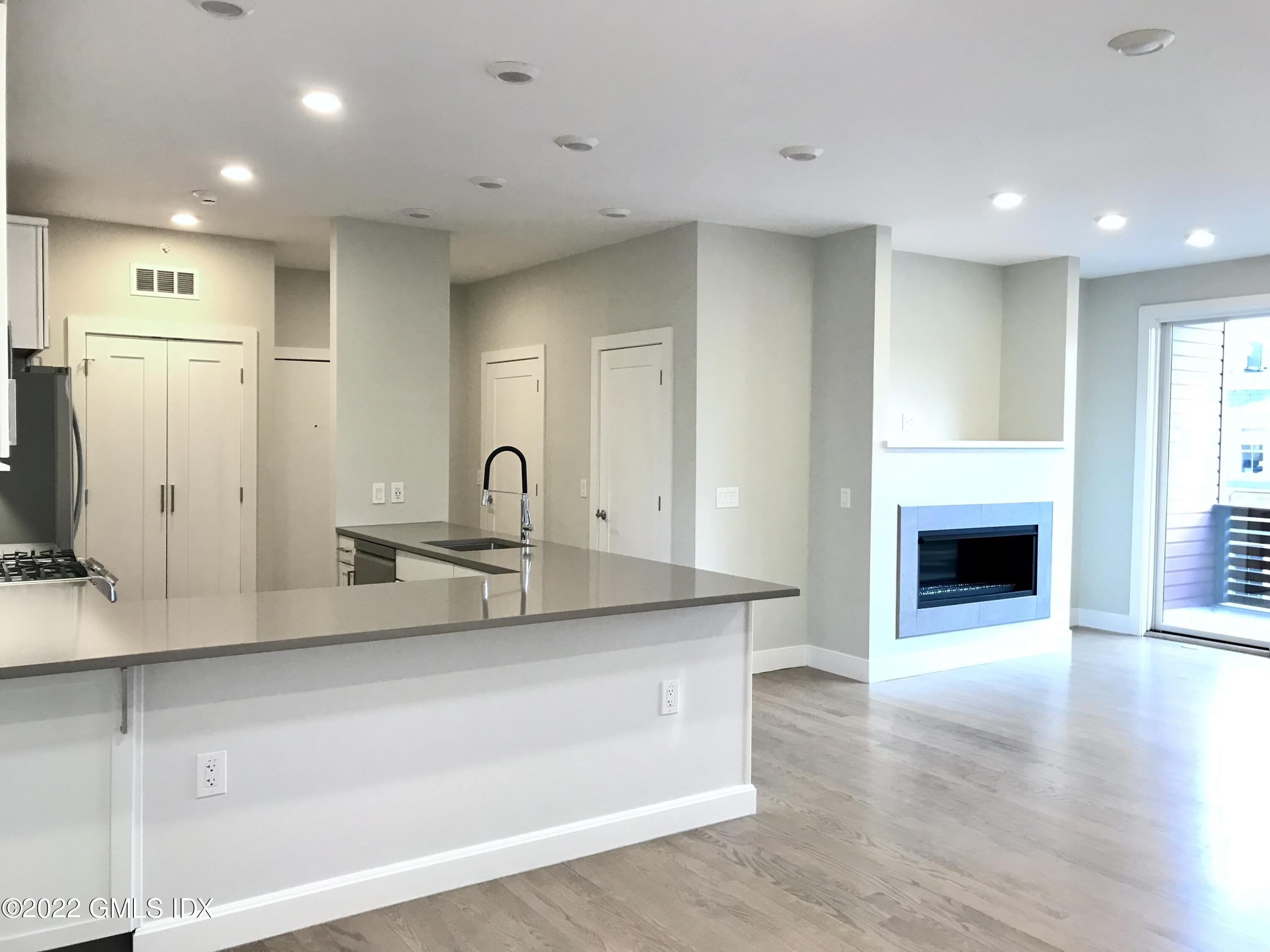 56 Old Field Point Road, Unit 6 Greenwich, CT 06830 - Photo 9 of 28 a kitchen with stainless steel appliances granite countertop a sink a stove and a refrigerator