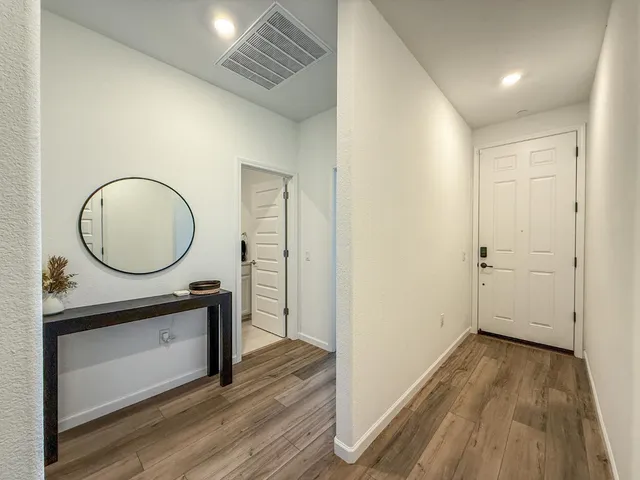 a view of a room with wooden floor and white walls