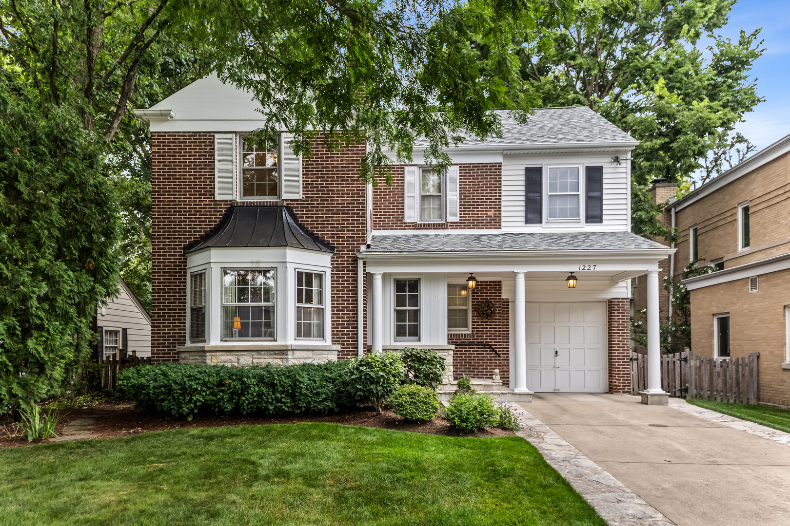 a front view of a house with a yard and trees