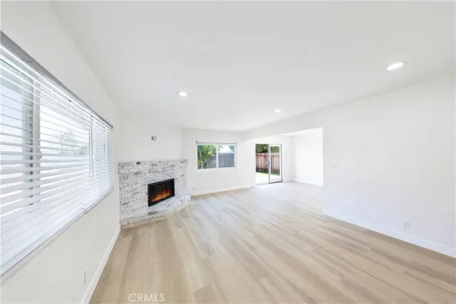 a view of empty room with fireplace and wooden floor