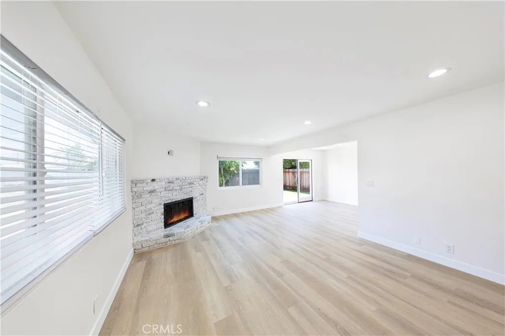 a view of empty room with fireplace and wooden floor