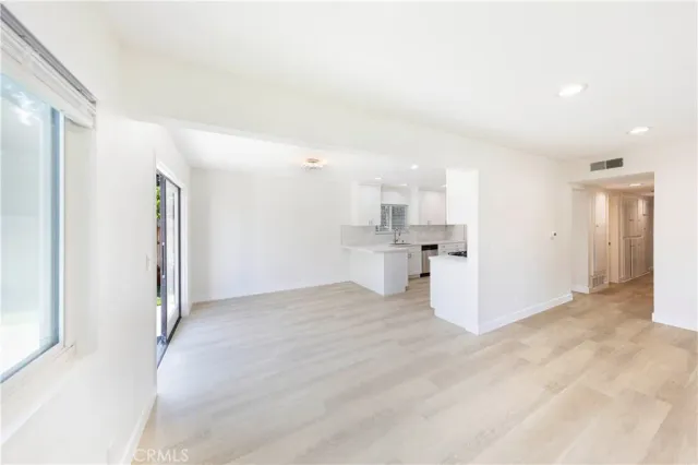 a view of a kitchen with refrigerator and white cabinets