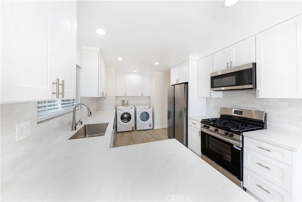2477 Orange, Unit A Costa Mesa, CA 92626 - Photo 7 of 21 a kitchen with stainless steel appliances kitchen island granite countertop a stove a sink and a microwave