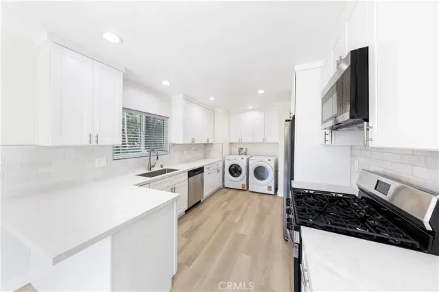 a kitchen with stainless steel appliances a sink stove and cabinets
