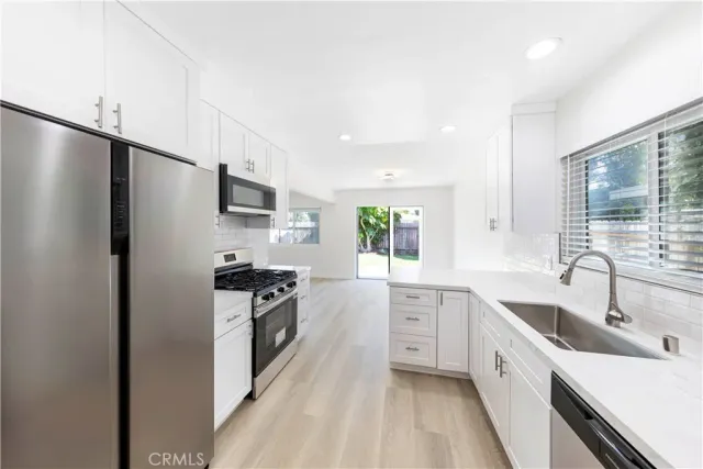 a kitchen with a sink stainless steel appliances and cabinets