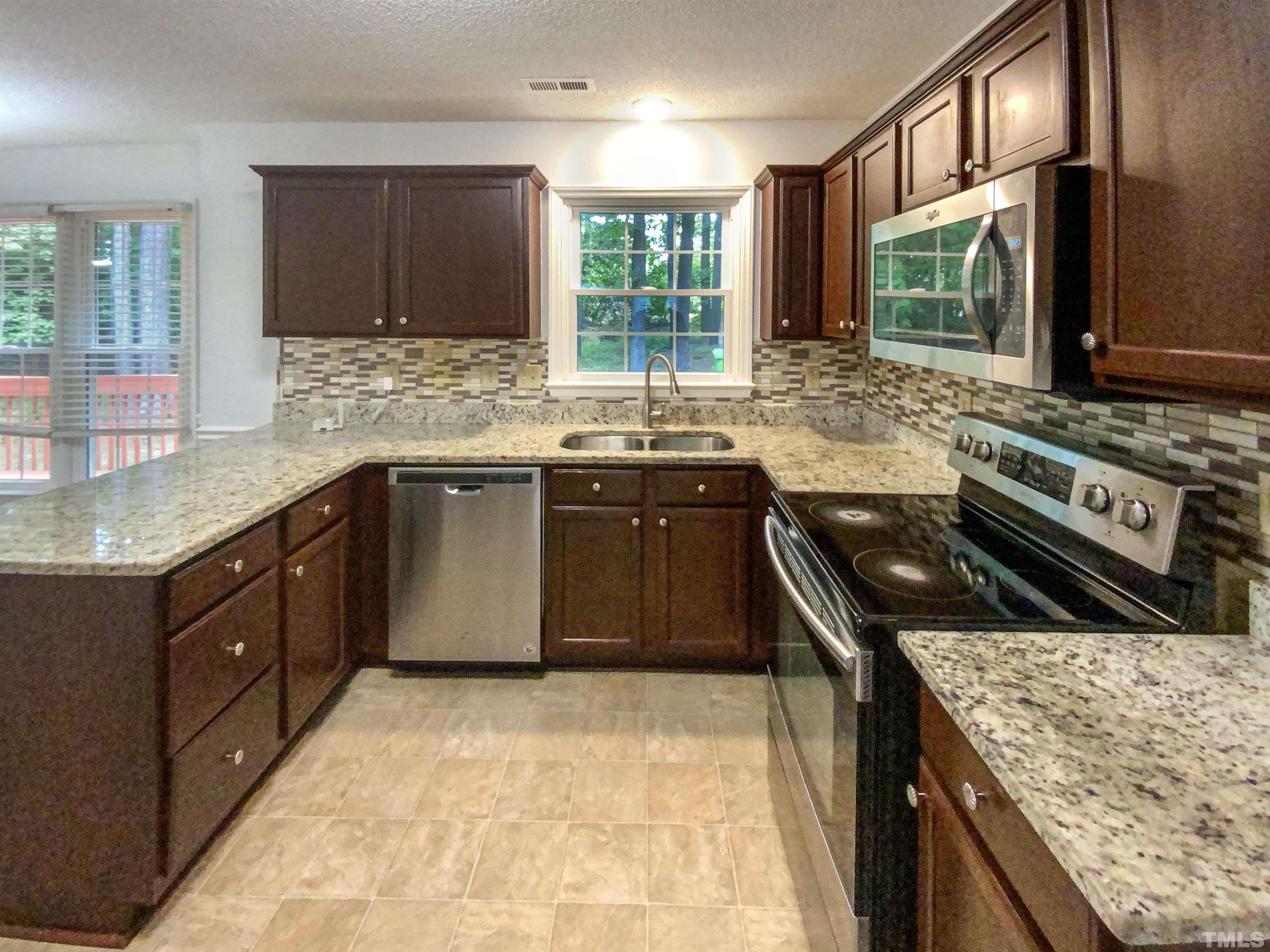 3416 Ribcowski Court Raleigh, NC 27616 - Photo 6 of 18 a kitchen with a stove sink and cabinets