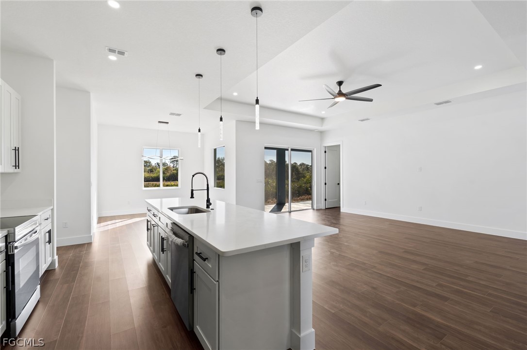 97 Brig Circle East Placida, FL 33946 - Photo 5 of 23 a hall with kitchen island a sink dishwasher a stove and a oven with wooden floor