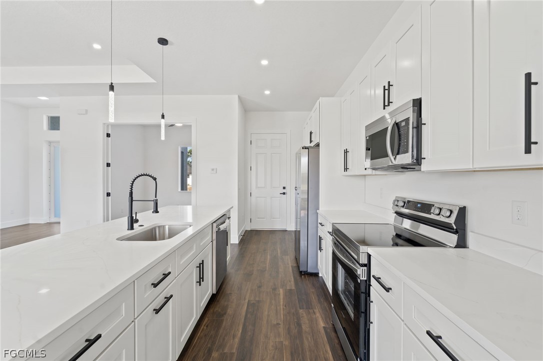 97 Brig Circle East Placida, FL 33946 - Photo 7 of 23 a kitchen with kitchen island white cabinets and stainless steel appliances