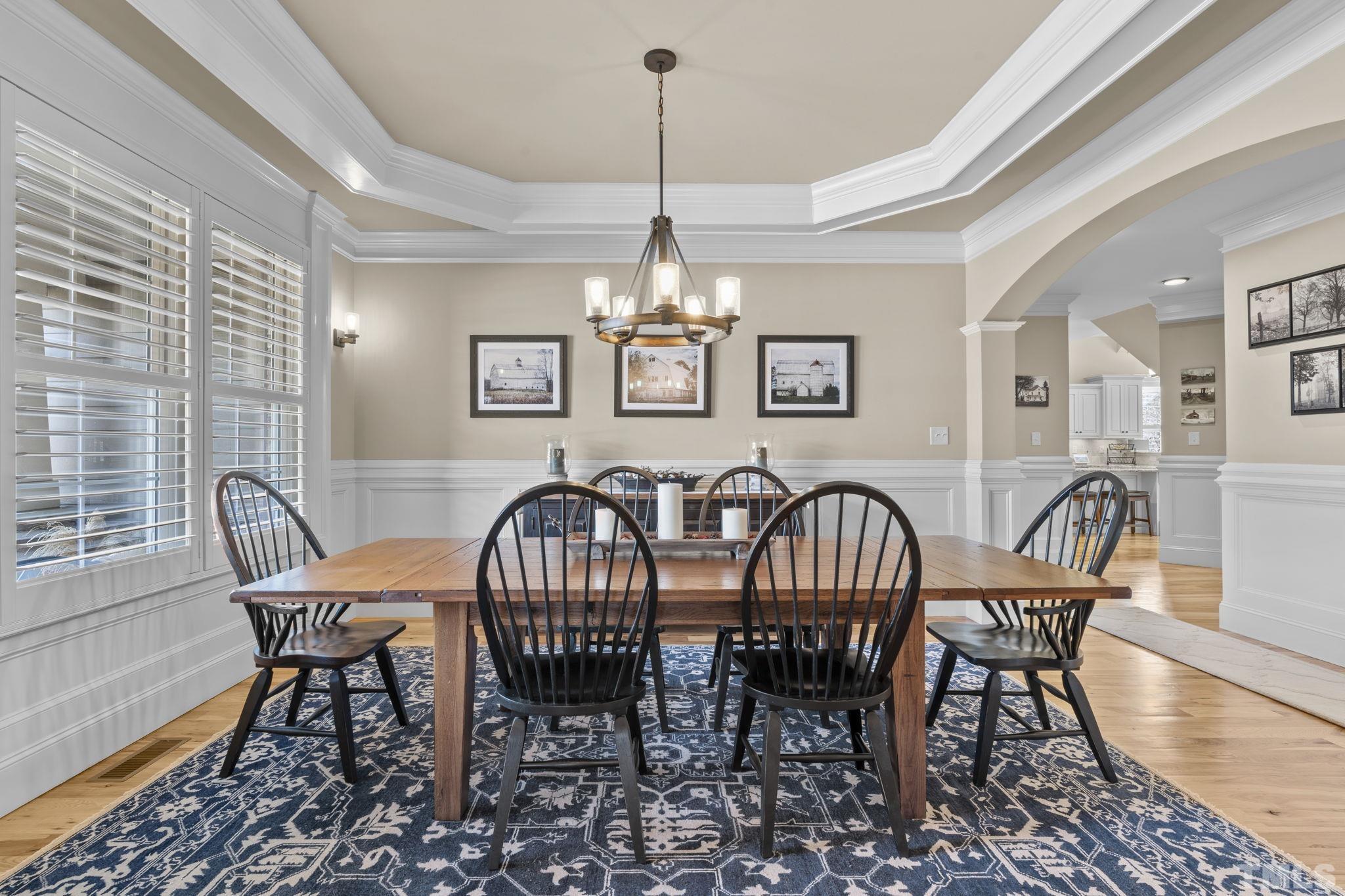 3976 Springfield Trail Wake Forest, NC 27587 - Photo 7 of 35 a dining room with furniture a chandelier and wooden floor