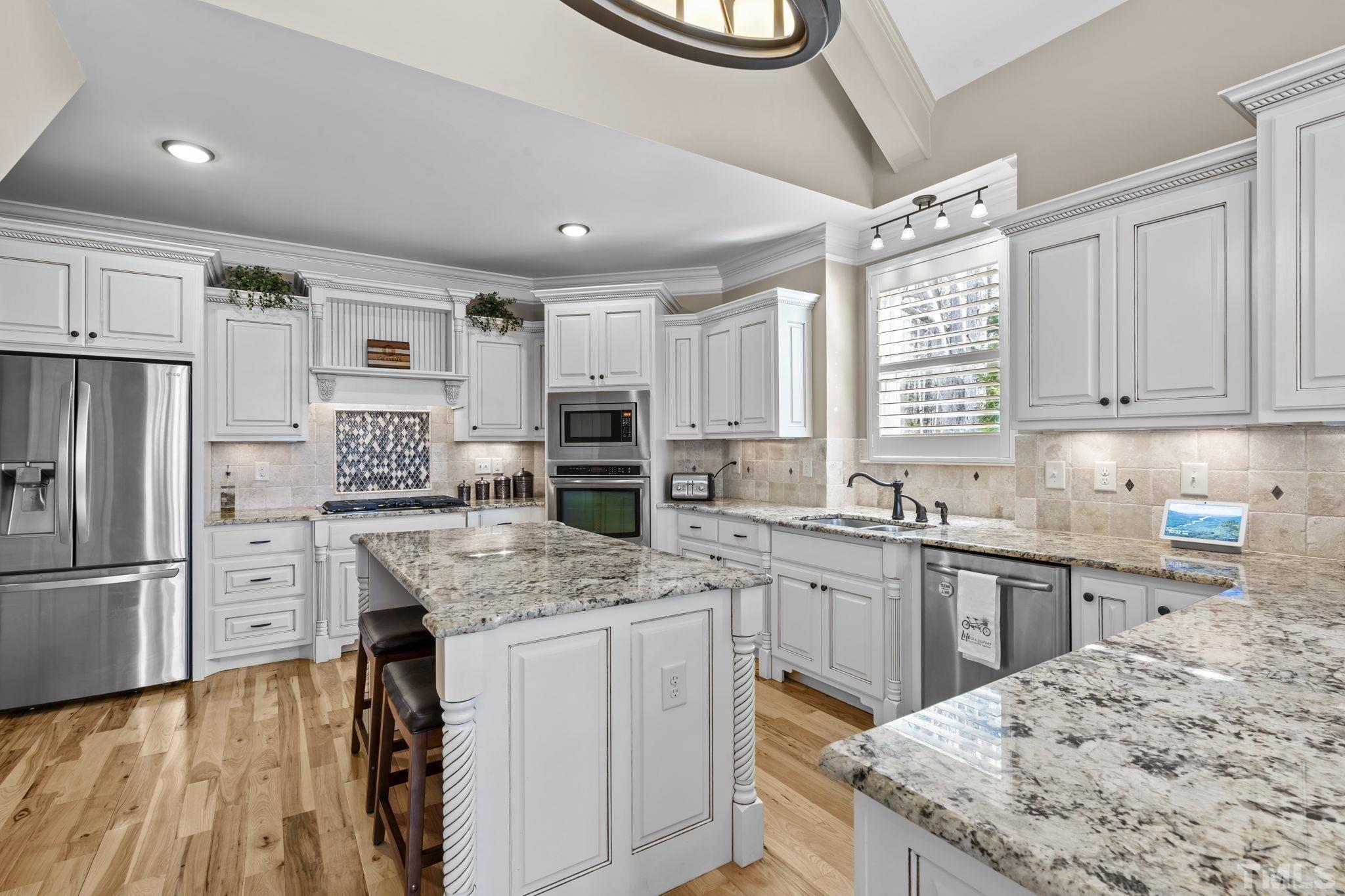 3976 Springfield Trail Wake Forest, NC 27587 - Photo 9 of 35 a kitchen with stainless steel appliances granite countertop a sink stove refrigerator and cabinets