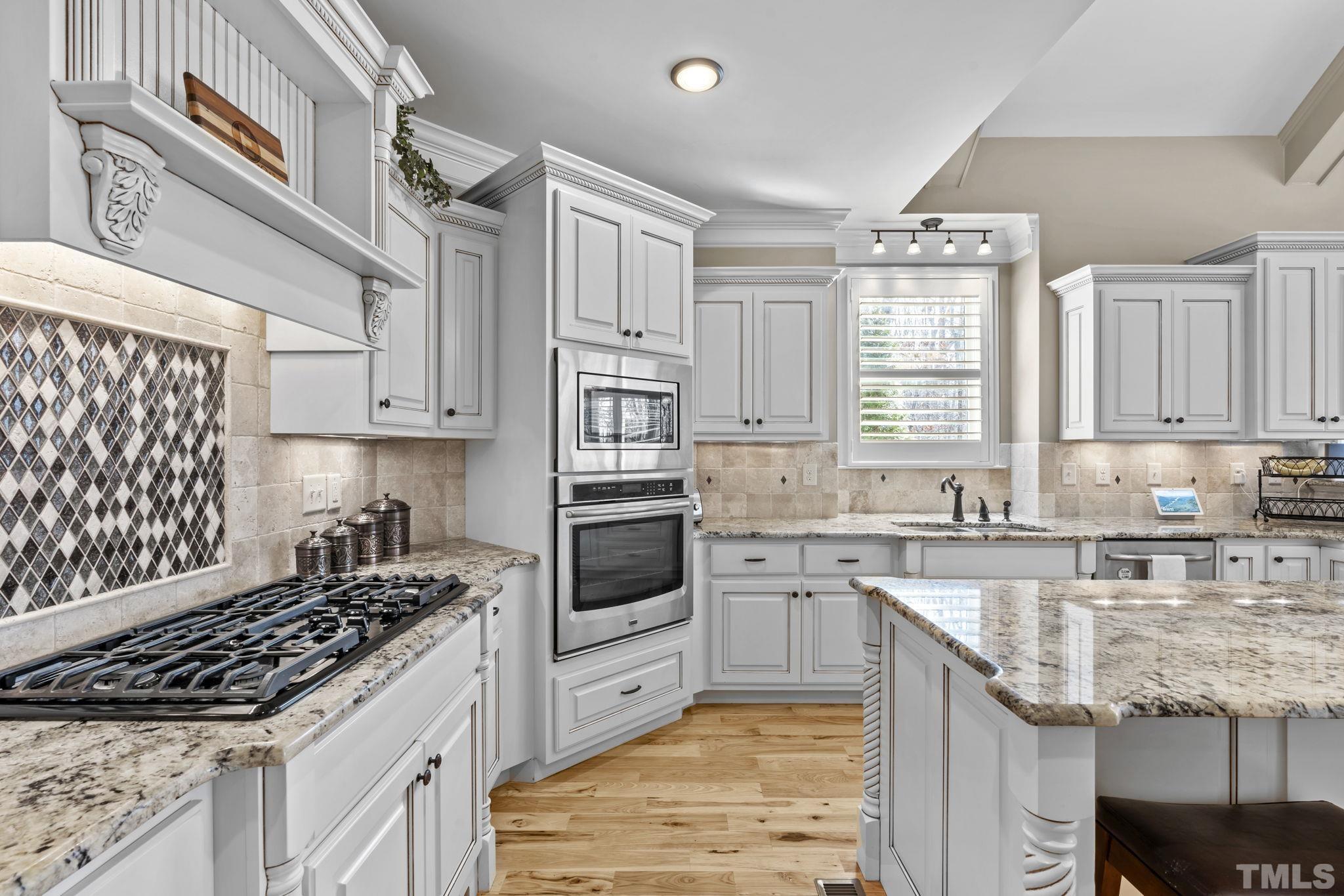 3976 Springfield Trail Wake Forest, NC 27587 - Photo 10 of 35 a kitchen with granite countertop a sink stove and cabinets