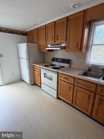 a kitchen with stainless steel appliances granite countertop a stove a sink dishwasher and a refrigerator
