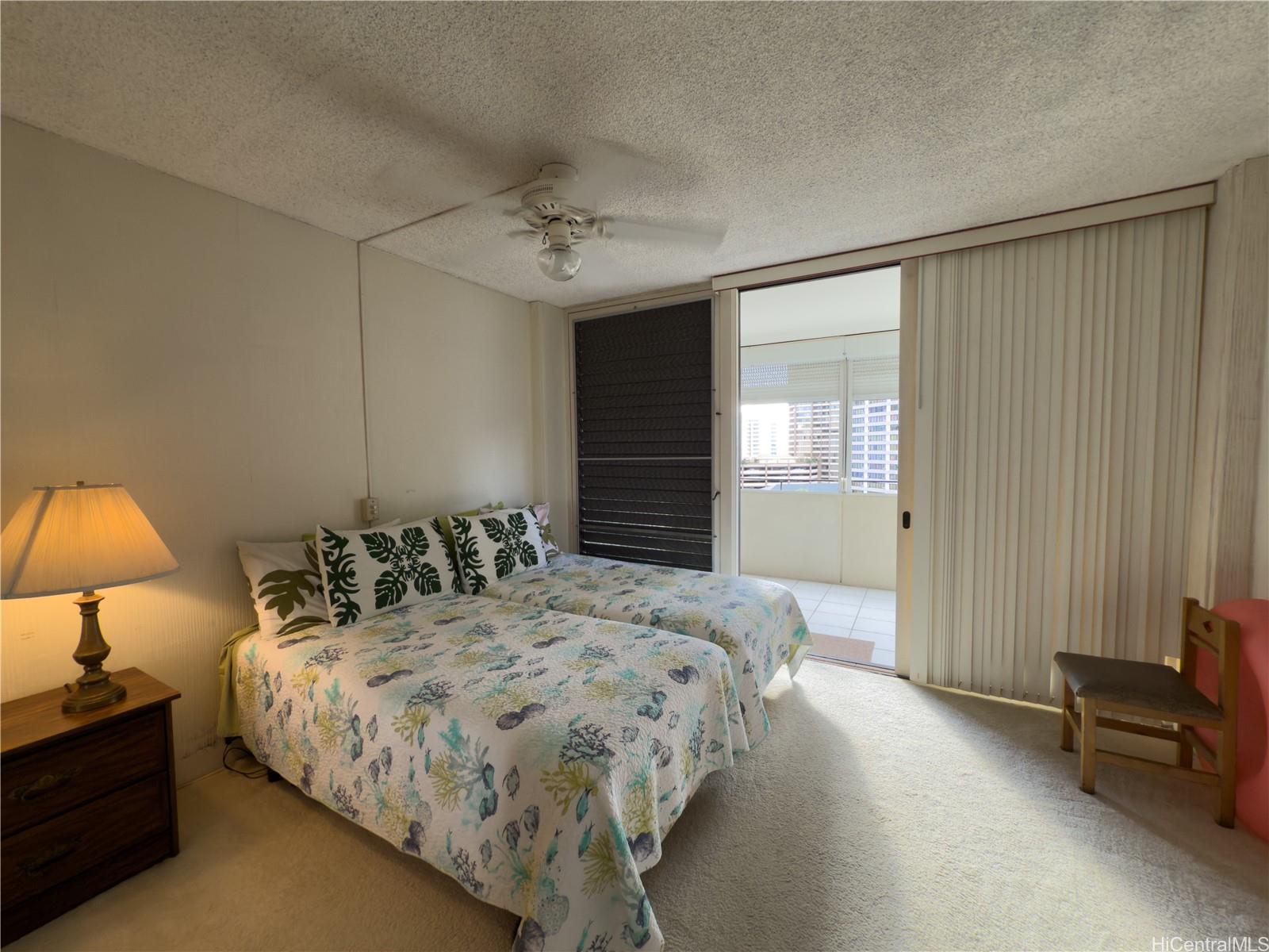 425 Ena Road, Unit 1201B Honolulu, HI 96815 - Photo 7 of 20 a bedroom with a bed and lamp with window