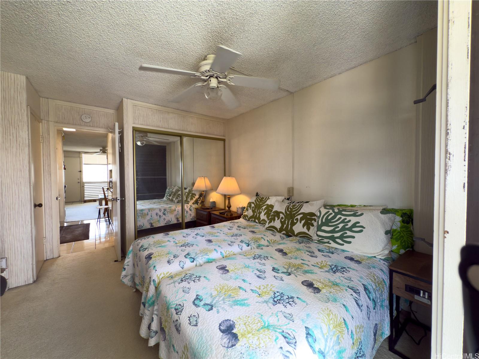 425 Ena Road, Unit 1201B Honolulu, HI 96815 - Photo 8 of 20 a bedroom with a large bed and a chandelier