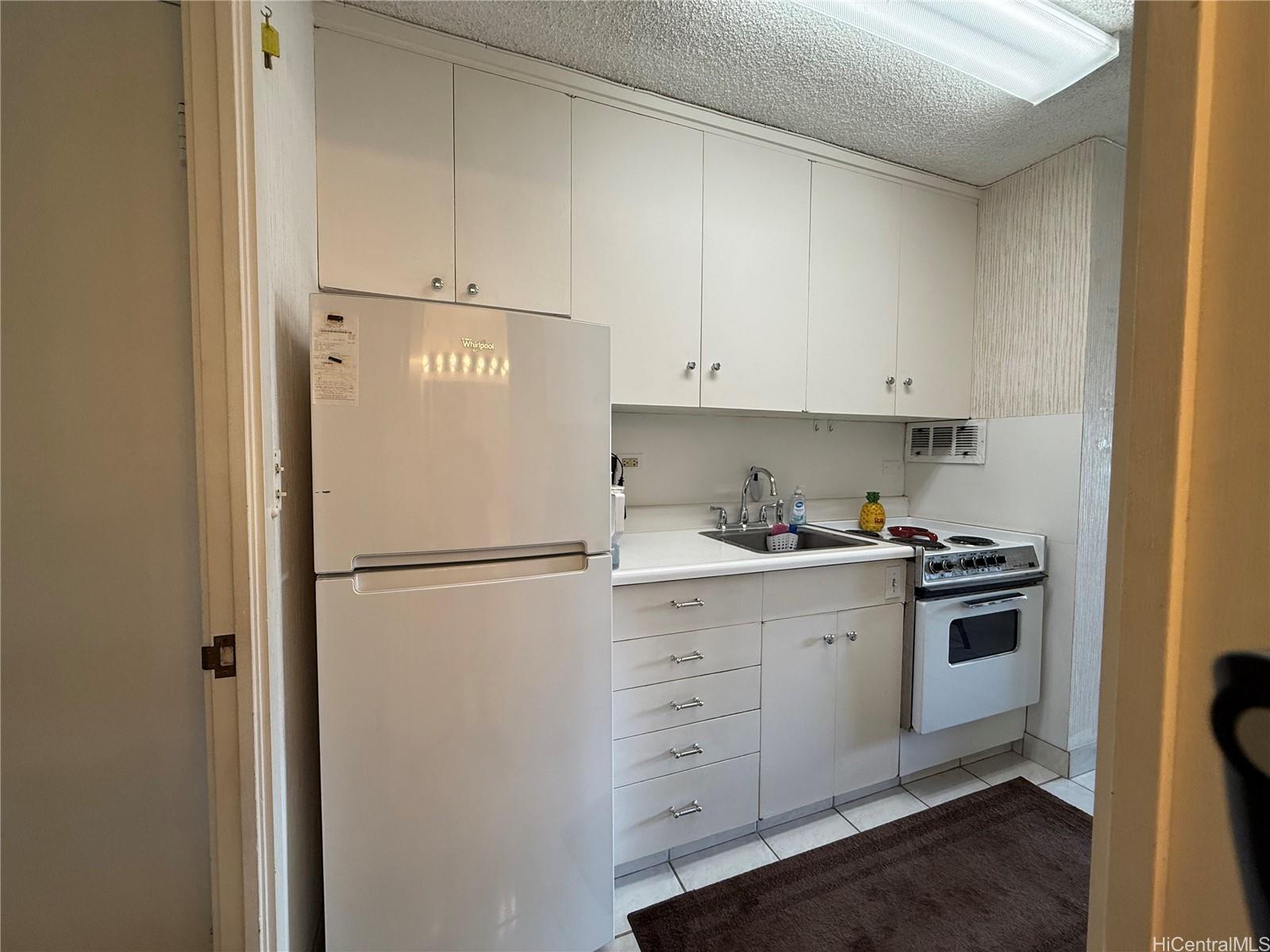 425 Ena Road, Unit 1201B Honolulu, HI 96815 - Photo 10 of 20 a white refrigerator freezer sitting in a kitchen