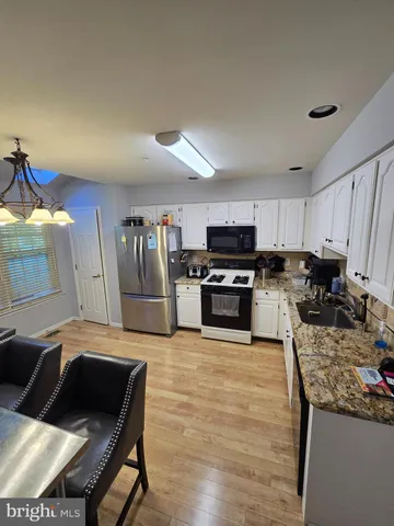 a kitchen with stainless steel appliances granite countertop a stove top oven a sink and dishwasher