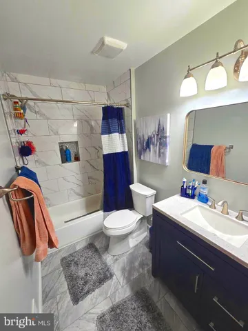 a bathroom with a sink vanity mirror and toilet