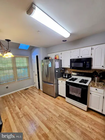a kitchen with stainless steel appliances granite countertop a stove and a refrigerator