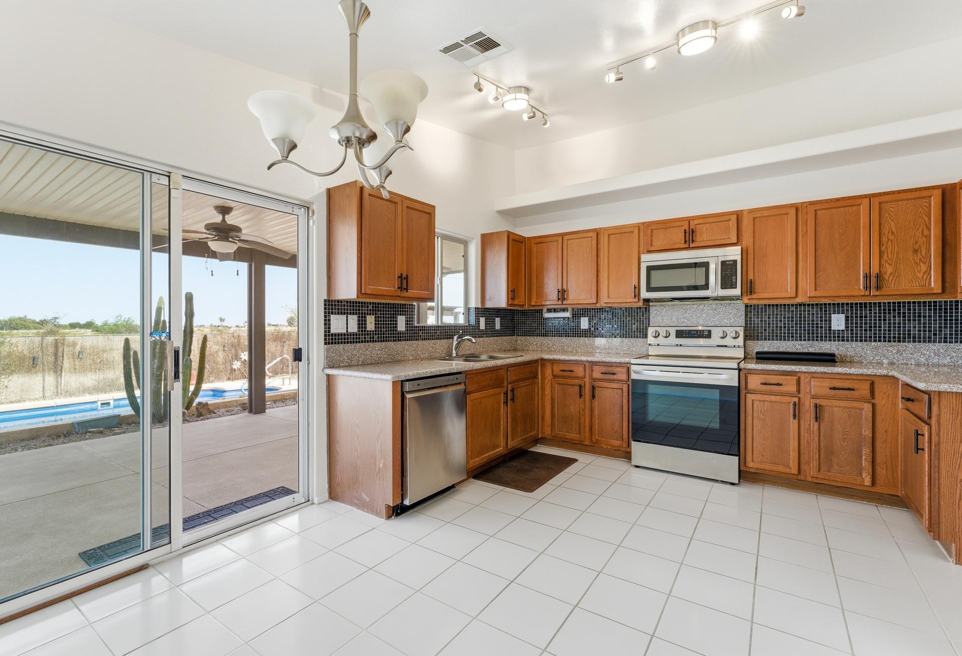 2776 Leto Avenue Thermal, CA 92274 - Photo 14 of 44 a kitchen with granite countertop a stove a sink and a refrigerator