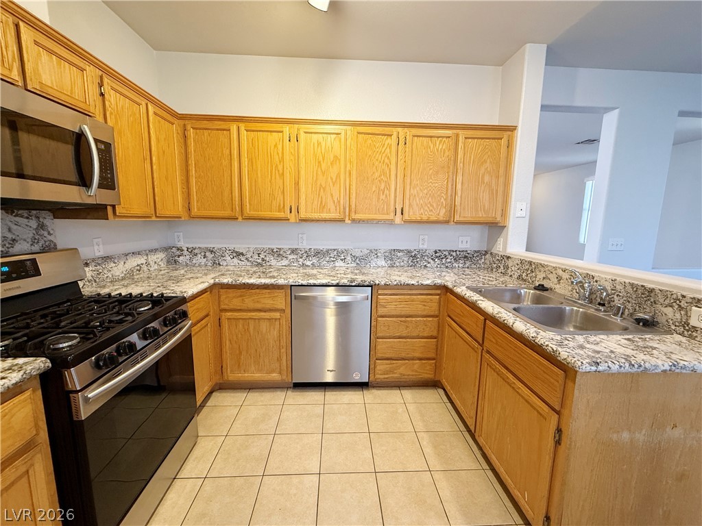 2185 Polynesia Circle Henderson, NV 89074 - Photo 12 of 37 A well-appointed kitchen features ample cabinetry, stone countertops, and modern stainless steel appliances.