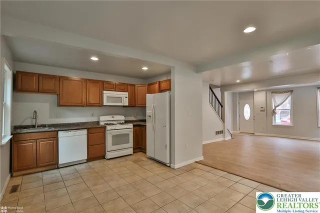 a kitchen with granite countertop white cabinets and white appliances