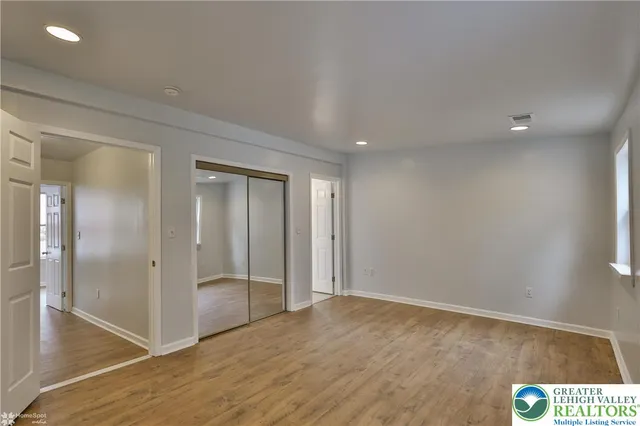 a view of a hallway with wooden floor and closet