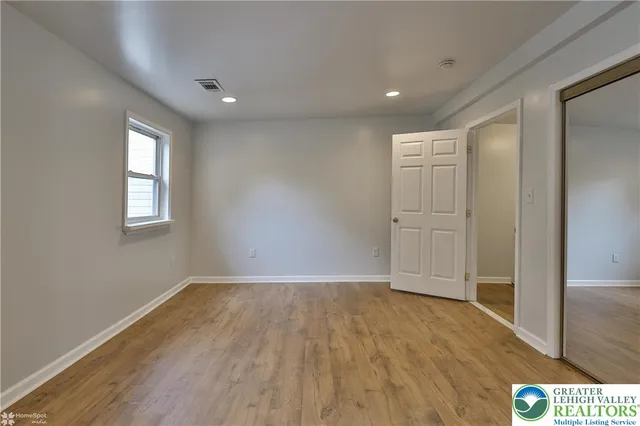 a view of hallway with windows and wooden floor